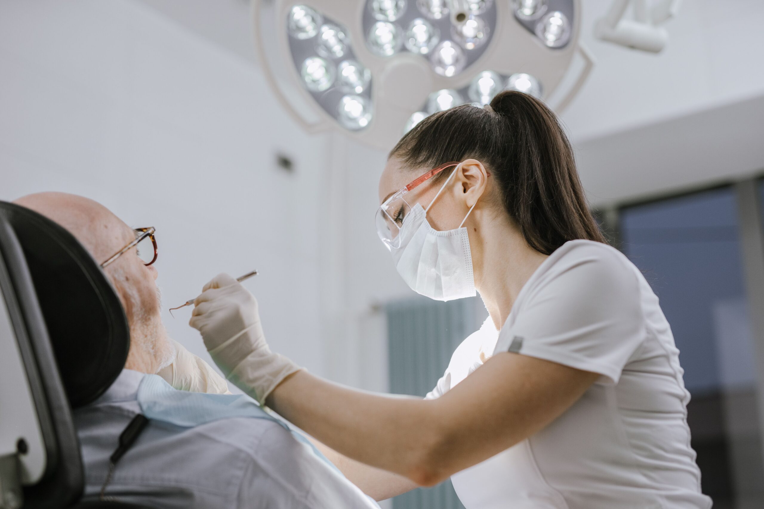 Dentista examinando paciente durante consulta odontológica.